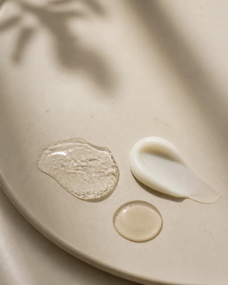 Three Korean skincare textures swept across cream ceramic